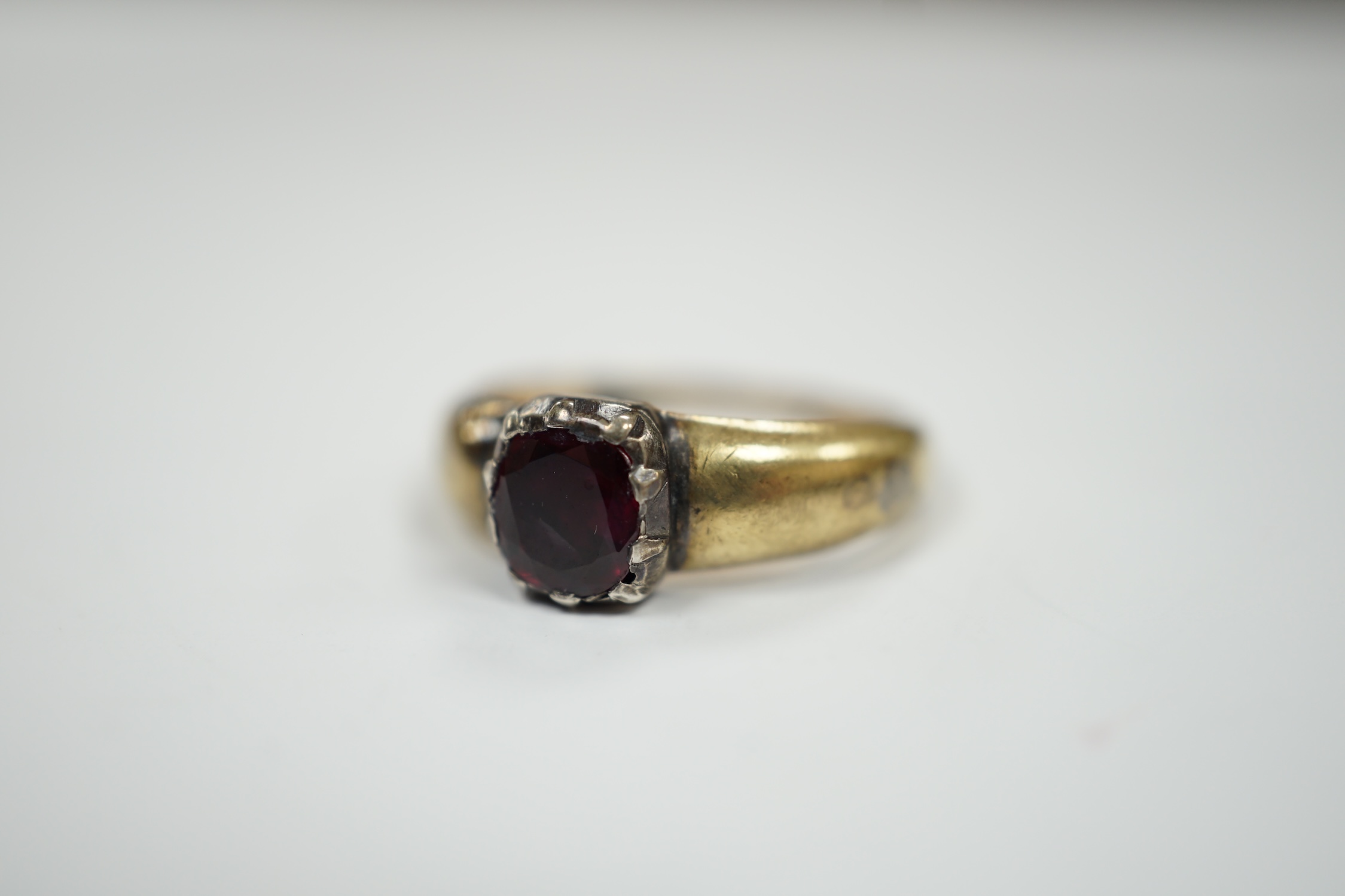A yellow metal and collet set solitaire ruby ring, size M, gross weight 3.2 grams.